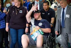 EMT Richard McMahon waves to supporters as he is released from Richmond University Medical Center in Staten Island Thursday.