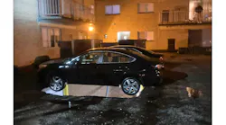 A vehicle is suspended by its bumpers after the decking collapsed into the garage below.