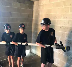 Three recruits from the engine company of their battalion prepare to extinguish more 'fire' on the second floor of the burn building.