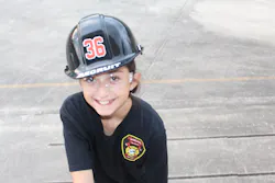 A recruit happily makes her climb up the ladder placed and raised at the drill tower by her and her partner.