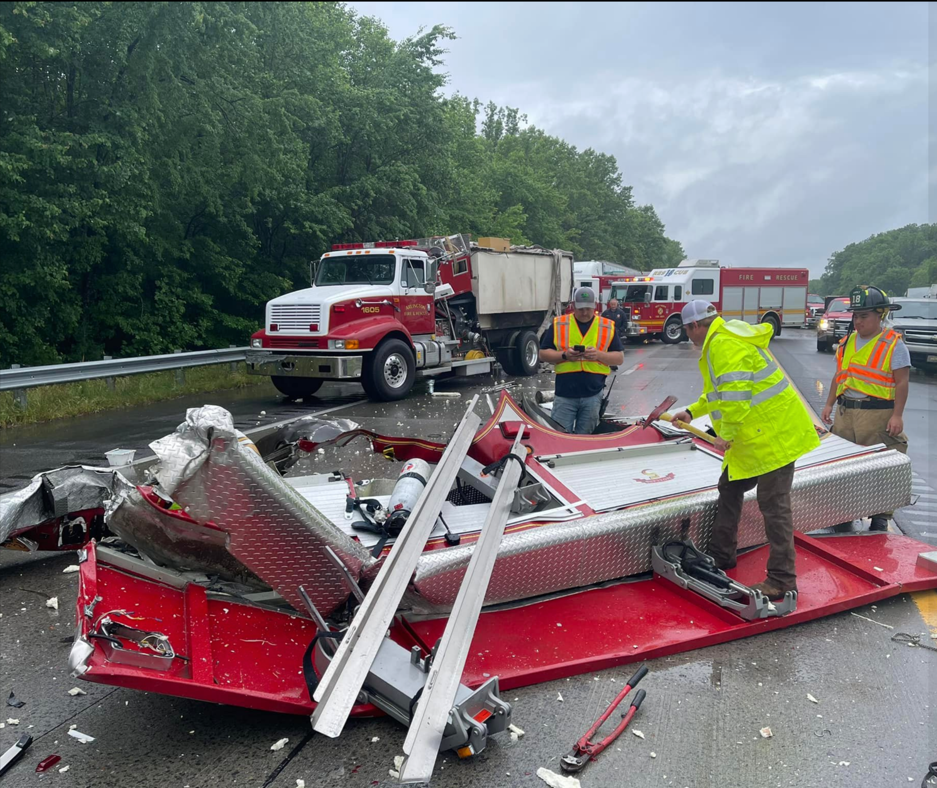 Arlington firefighters begin salvaging what equipment they can from the wrecked pumper-tanker.