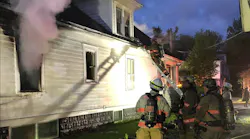 A Syracuse, New York firefighter vents the dormer windows at a vacant building fire Sunday night.