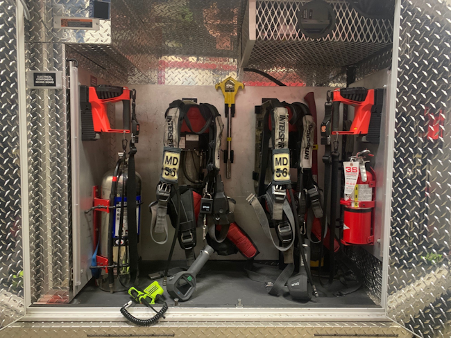 This is a standard street-side PPE and equipment cabinet for fire-based EMS medic units, but a curbside location of such a compartment provides a safer place for members who are on the medic unit to don their gear. Inset: Locating the curbside patient door forward on the box affords that person privacy when the door is open.