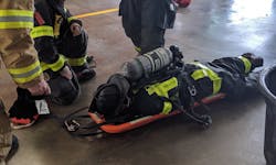 Often, the use of a stokes basket to remove a downed firefighter from a roof via an aerial ladder isn’t possible, because the stokes basket’s width is greater than the width of the fly section of the aerial. Members of a RIT can use a FAST board instead, but they should train on the maneuver, because, typically, only half of a firefighter’s body fits on the board, making for a challenging descent. Often, the use of a stokes basket to remove a downed firefighter from a roof via an aerial ladder isn’t possible, because the stokes basket’s width is greater than the width of the fly section of the aerial. Members of a RIT can use a FAST board instead, but they should train on the maneuver, because, typically, only half of a firefighter’s body fits on the board, making for a challenging descent.