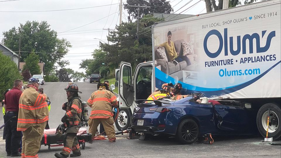 Firefighters work to extricate a patient trapped inside a car that collided with a truck in East Syracuse.