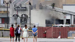 Beachgoers watch as firefighters battle a fire on the Boardwalk in Atlantic City on Friday morning.