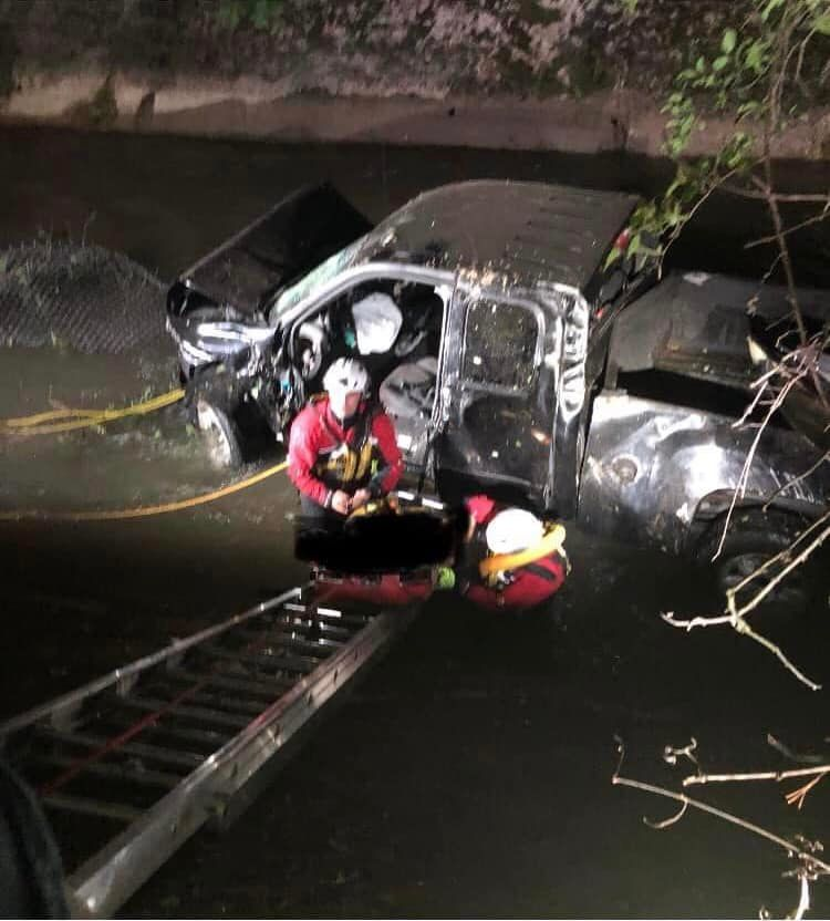 Syracuse firefighters donned wet suits and climbed down a ladder to rescue the two men after their truck went down a 20-foot embankment.