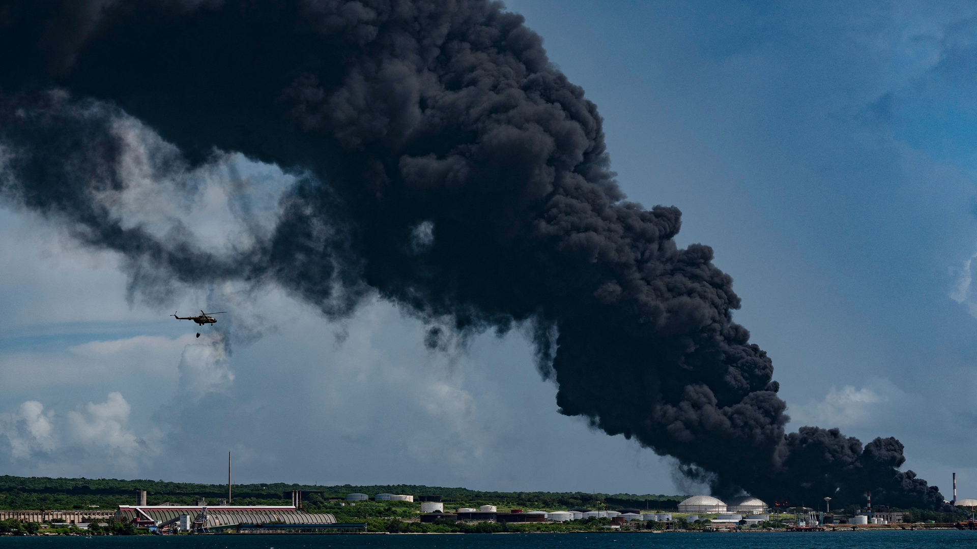 A firefighting helicopter near the scene of the the oil tank fire in Matanzas, Cuba, on Saturday.