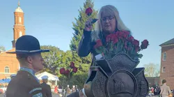 Traci Adams Swartz places roses at the entrance of National Fallen Firefighter Memorial early Sunday morning.