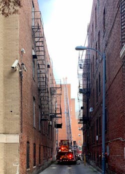 Firefighters made their way down a narrow alley to set up the ladder.