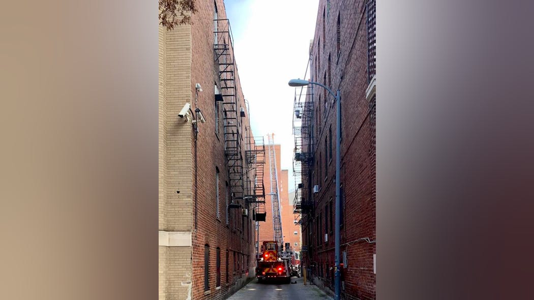 Firefighters made their way down a narrow alley to set up the ladder.