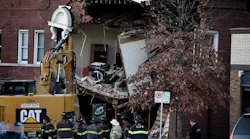 Firefighters and other officials at the scene of the Dec. 15, 2021 crash where a Kansas City Fire Department pumper struck a vehicle and building, leaving three dead.