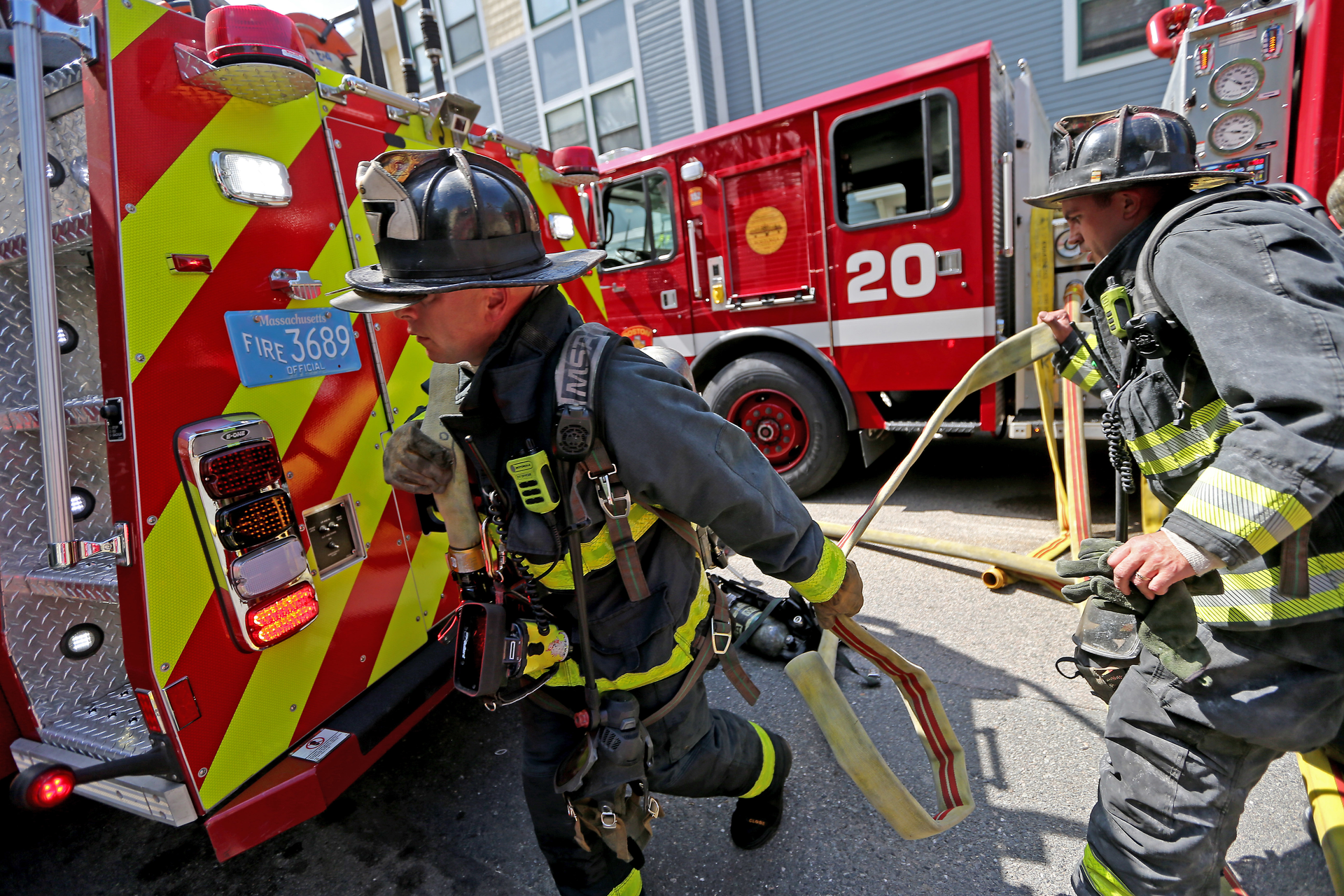 Boston firefighters grab a line at a recent house fire.
