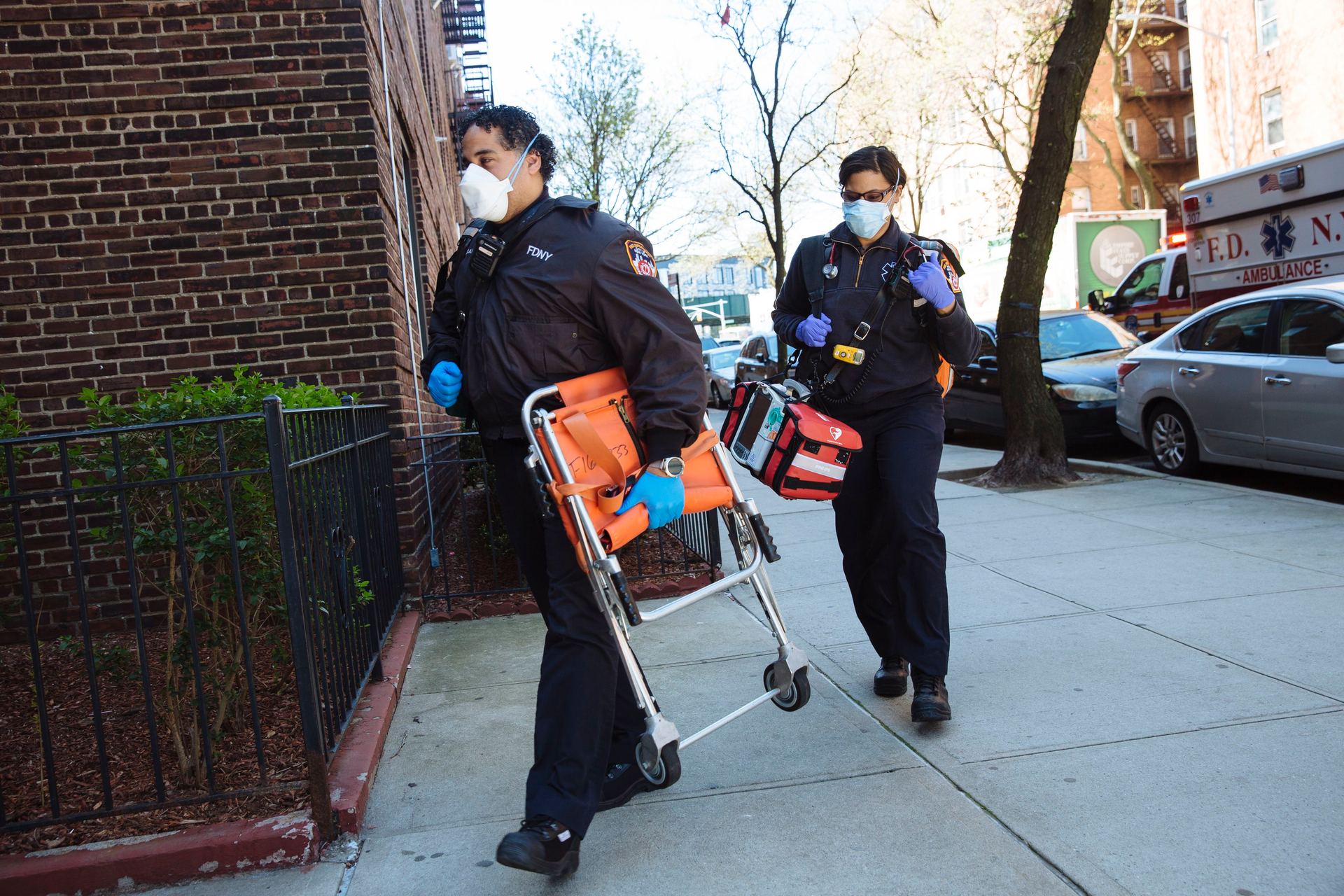 FDNY medics carry gear into a residence.
