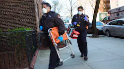 FDNY medics carry gear into a residence.