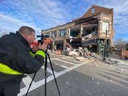 A firefighter uses a laser to search for movement in a building. A firefighter uses a laser to search for movement in a building.