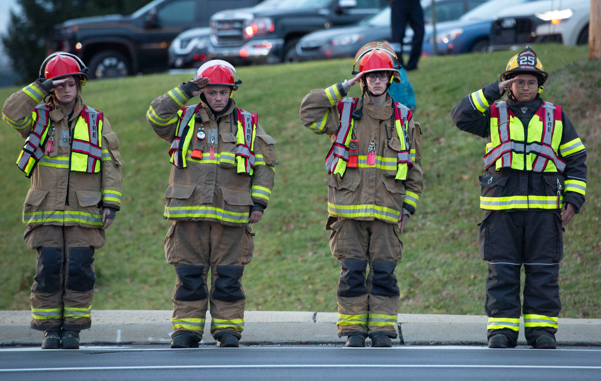 Local firefighters salute as the hearses carrying the bodies of fallen colleagues pass.