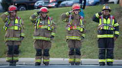 Local firefighters salute as the hearses carrying the bodies of fallen colleagues pass.