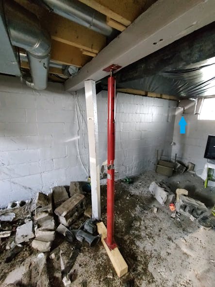 Manufactured posts may be utilized to support structural components in certain situations. Notice the damage to the foundation wall (blue arrow). This damage is on the opposite side from where the vehicle crashed into the home and illustrates the importance of a 360-degree size-up.