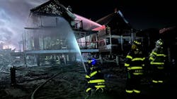 Duxbury firefighters pour water on one of the homes that burned in Scituate Friday night. Duxbury firefighters pour water on one of the homes that burned in Scituate Friday night.