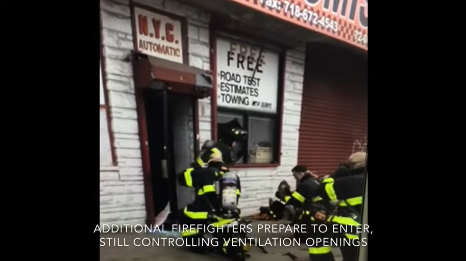 Engine company firefighters await orders from crews searching for the fire in the commercial building.