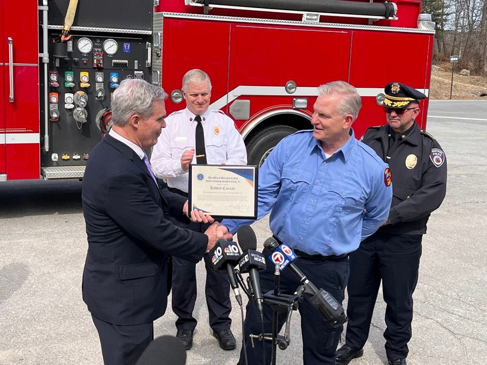 Harvard Fire Department firefighter and drone operator Robert Curran receives the TEAM Award from Worcester County District Attorney Joseph Early Jr.