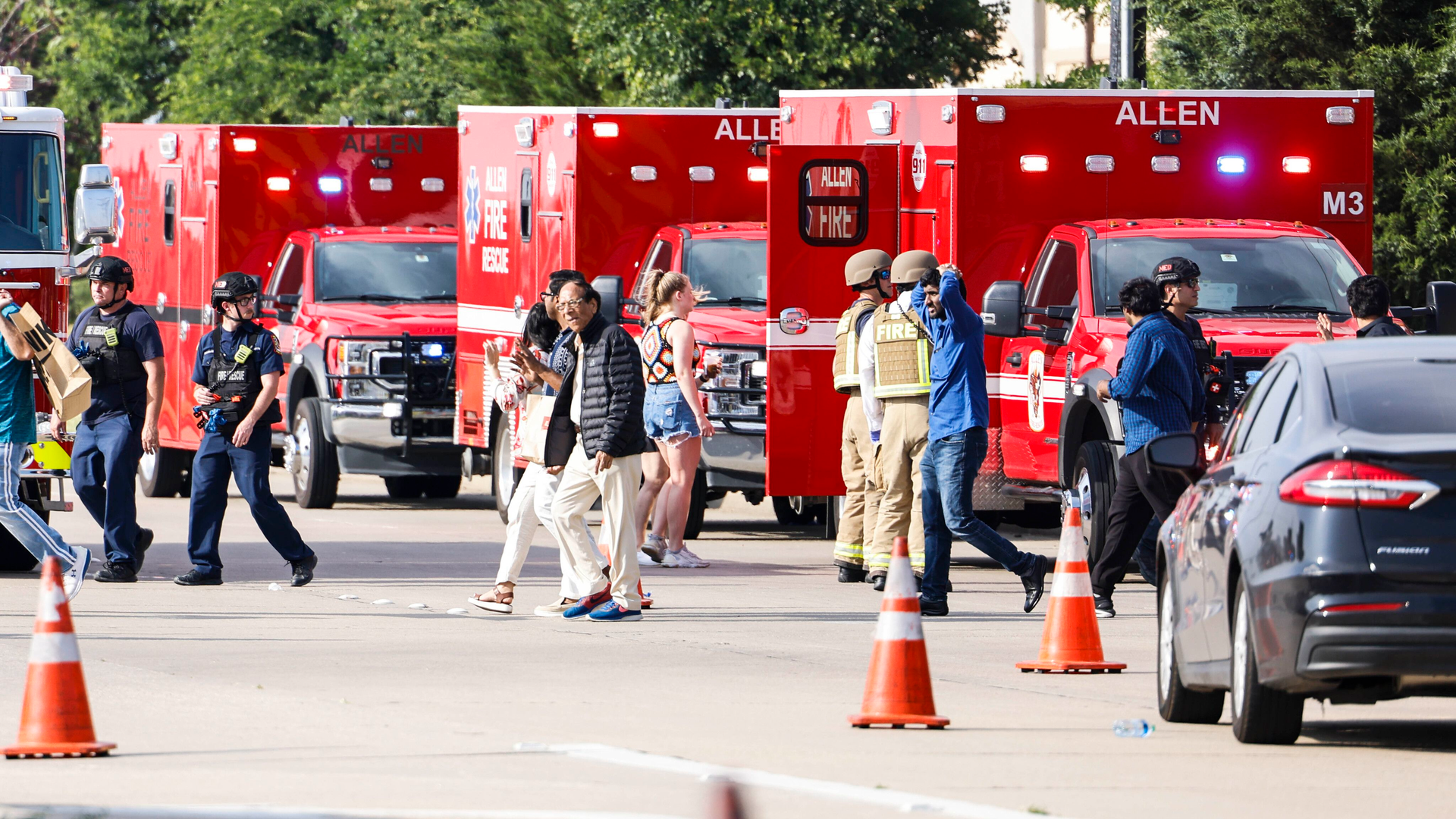 People gather outside the at Allen Premium Outlets mall after a shooting on May 6 in Allen, TX.