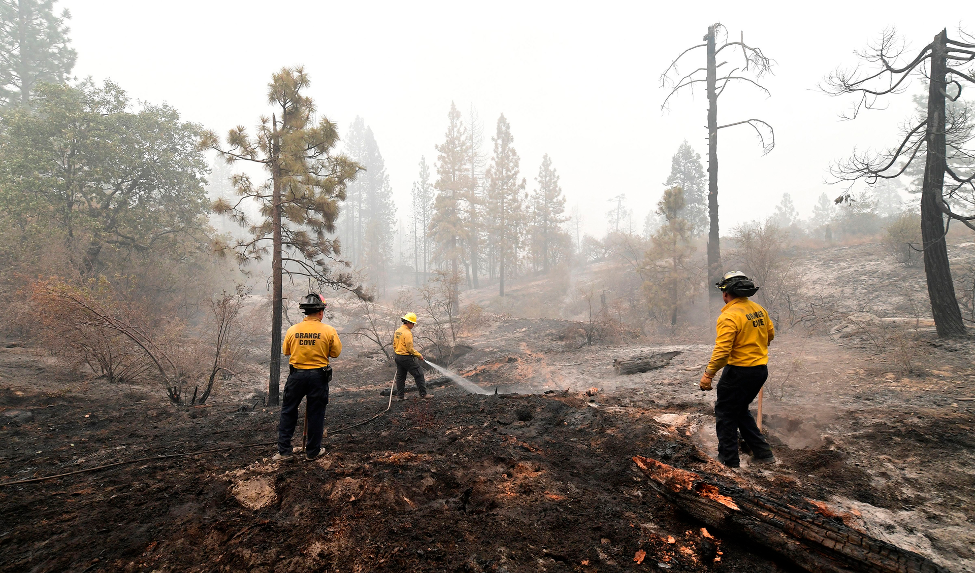 In this file photo, firefighters put out burning embers in the Fresno County community of Bald Mountain, in the foothills of the Sierra Nevada mountains, on Sept. 11, 2020.