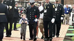 A boy clings to a flag he was presented during the National Fallen Firefighters Memorial Service.