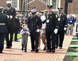 A boy clings to a flag he was presented during the National Fallen Firefighters Memorial Service.