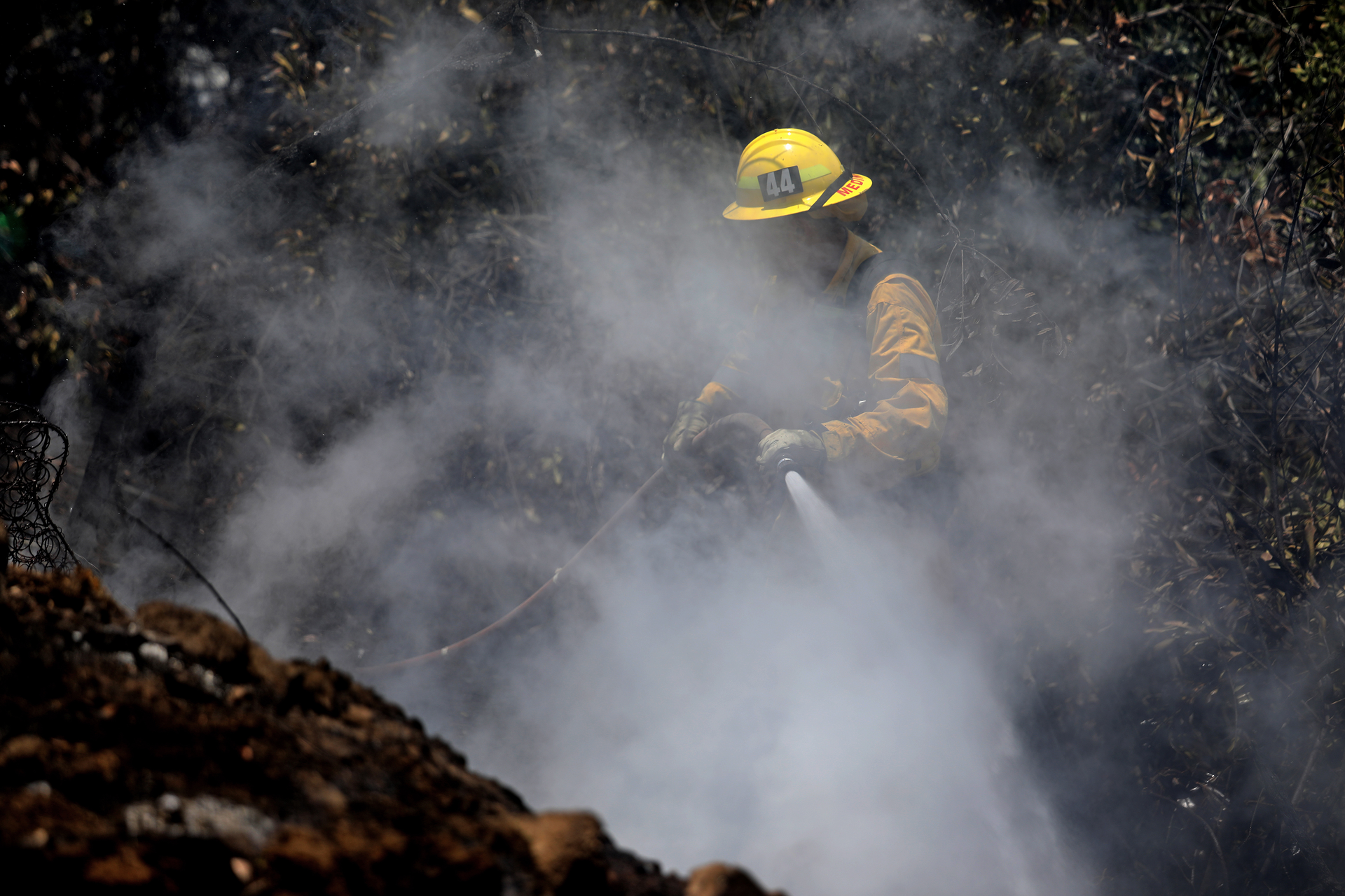 A Los Angeles firefighter hits hotspots.