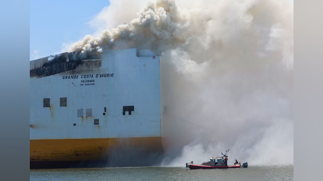 Smoke pours from the Grande Costa D&apos;Avorio cargo ship Thursday afternoon, hours after two Newark firefighters died while battling a fire reported Wednesday night.