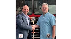 Dinges Fire Company Chief Executive Officer Nick Dinges shakes hands with HME Ahrens-Fox Vice President, Sales, Dave Rider.