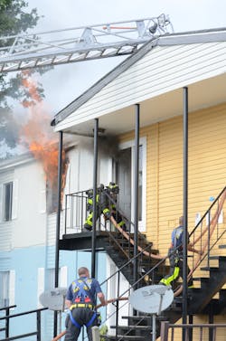 Photo 3: Knowing when it&apos;s OK for the driver/operator to tactically assist is critical. Here, two drivers are assisting to properly staff the first attack line, which will push more than 50 feet inside to make it to the final room of fire.