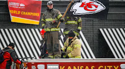A firefighter waves a flag atop an engine during the 2020 Super Bowl parade.