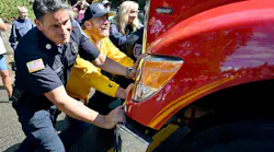 Shaver Lake firefighter David Eggers, left, with help from Fresno County Supervisor Nathan Magsig, push E-260 into the station.