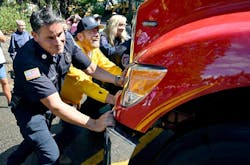 Shaver Lake firefighter David Eggers, left, with help from Fresno County Supervisor Nathan Magsig, push E-260 into the station. Shaver Lake firefighter David Eggers, left, with help from Fresno County Supervisor Nathan Magsig, push E-260 into the station.