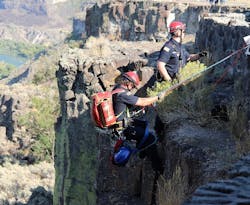TFFD firefighters descend over the edge of the cliff walls of the Snake River Canyon to work with the SORT team to rescue an injured hiker.