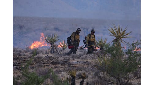 Crane Valley Hotshot firefighters walk as the York Fire burns in the Mojave National Preserve on July 30.