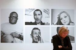 CDC Museum Director Judy Gantt stands in front of portraits of members of the WTC Health Program at 'The Health Effects of 9/11' exhibit at The David J. Sencer CDC Museum.