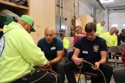 John Finley (left) of the Grangeville Mountain Rescue Unit shows Justin Aspiazu of the Meadows Valley Fire Department how to tie a knot in a rescue rope while Council Volunteer firefighter Kurt Yoder concentrates on tying his knot.