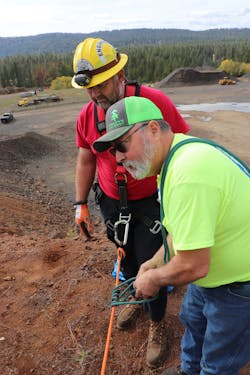 Brian Adams (right) of the Grangeville Mountain Rescue Unit shows Indian Valley Volunteer Fire Department engineer Josh Barritt how to tie into a rope prior to rappelling down the rock face. Brian Adams (right) of the Grangeville Mountain Rescue Unit shows Indian Valley Volunteer Fire Department engineer Josh Barritt how to tie into a rope prior to rappelling down the rock face.