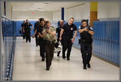 Police officers, firefighter and EMS crews evacuate a victim during an active shooter training scenario in Hennepin County.