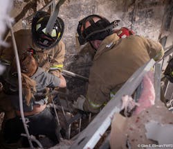 Firefighters pull a woman from debris after she was rescued from the explosion. Firefighters pull a woman from debris after she was rescued from the explosion.