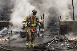 A firefighter operating at a structure fire. A firefighter operating at a structure fire.