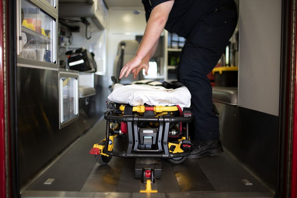A medic straightens the cot.