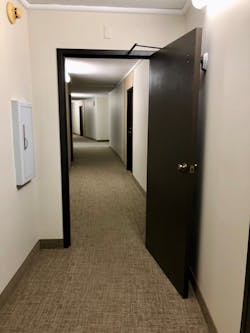 At apartment buildings, commercial buildings and high-rises, an electromagnetic door closure on a fire door causes the door to close when the alarm system is activated. This can trap firefighters behind the door with no water if a hoseline is trapped under the door opening.