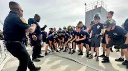 Explorers and advisors cheer as an explorer pulls hose across a line during the monster.