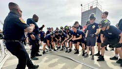 Explorers and advisors cheer as an explorer pulls hose across a line during the monster. Explorers and advisors cheer as an explorer pulls hose across a line during the monster.
