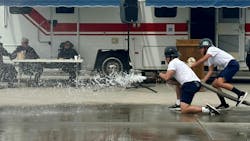 An explorer opens the nozzle to flow water and hit a target during the muster competition. An explorer opens the nozzle to flow water and hit a target during the muster competition.